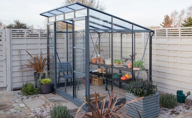 Freya greenhouse in a small garden/patio area