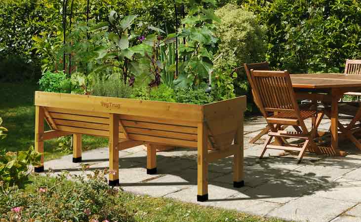 a Vegepod planter filled with crops in a patio area